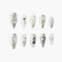 Silver and white press-on nails with glitter, stars, bows, pearls, and heart accents