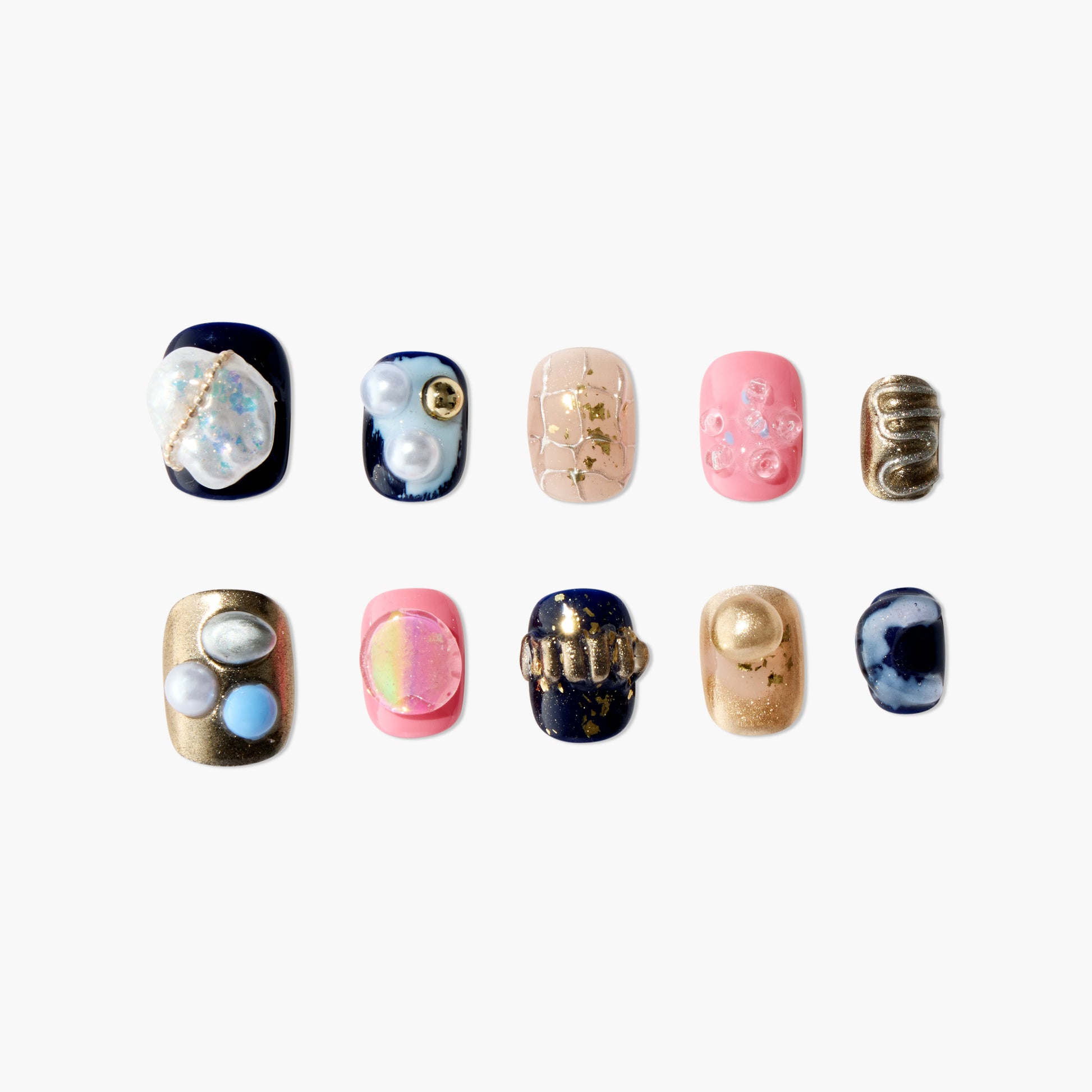Assorted handmade press-on nails with 3D pearl, gold, pink, and marble designs on white background