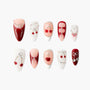 Handmade press-on nails set in red, pink, and white tones with cherry charms and metallic bows