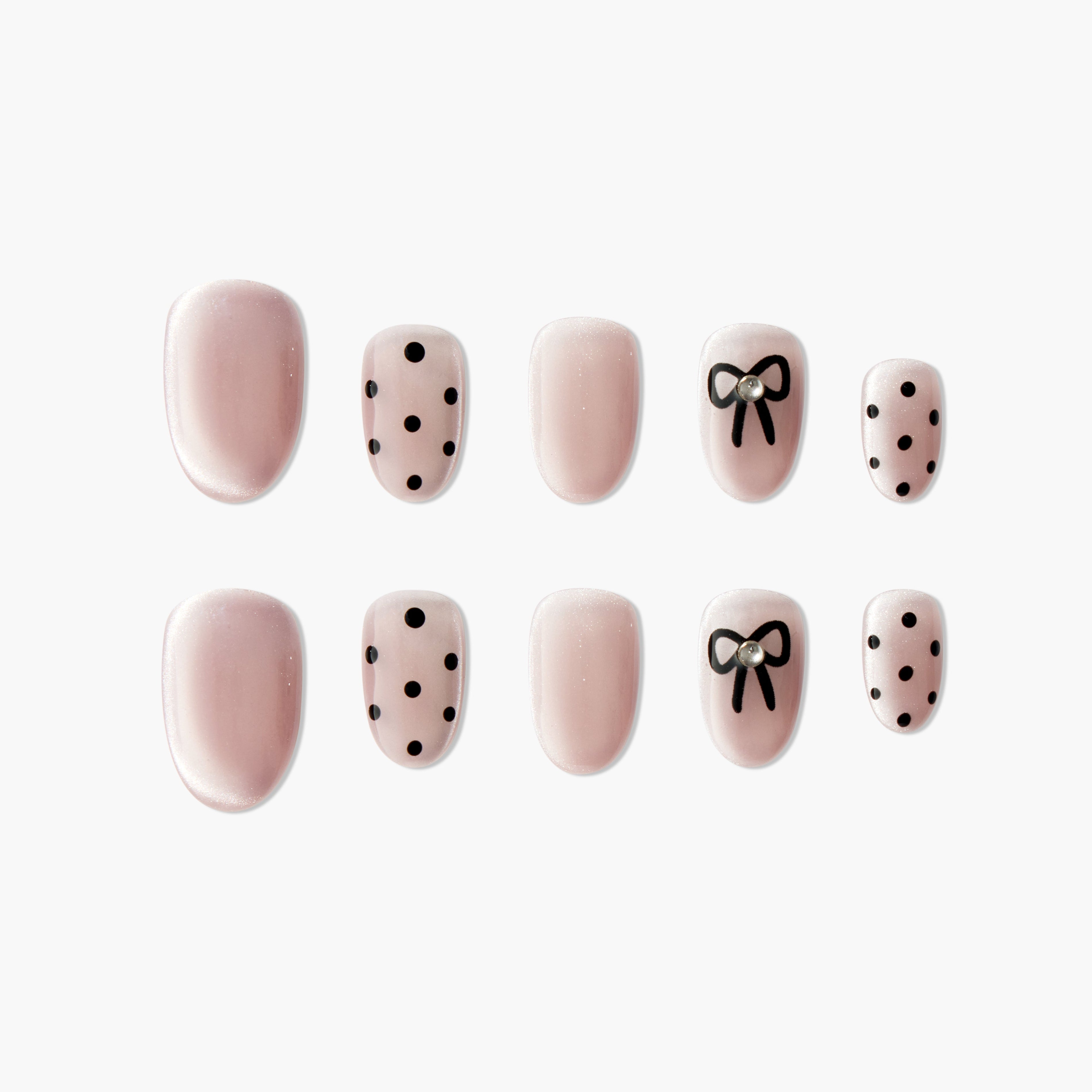 Pink press-on nails with black polka dots and bow design, pearl accent, glossy finish