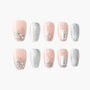 Winter press-on nails with pink, silver glitter, snowflakes, jewels, and snowman designs.
