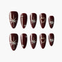Burgundy press-on nails with silver star and heart designs, rhinestone accents, on white background