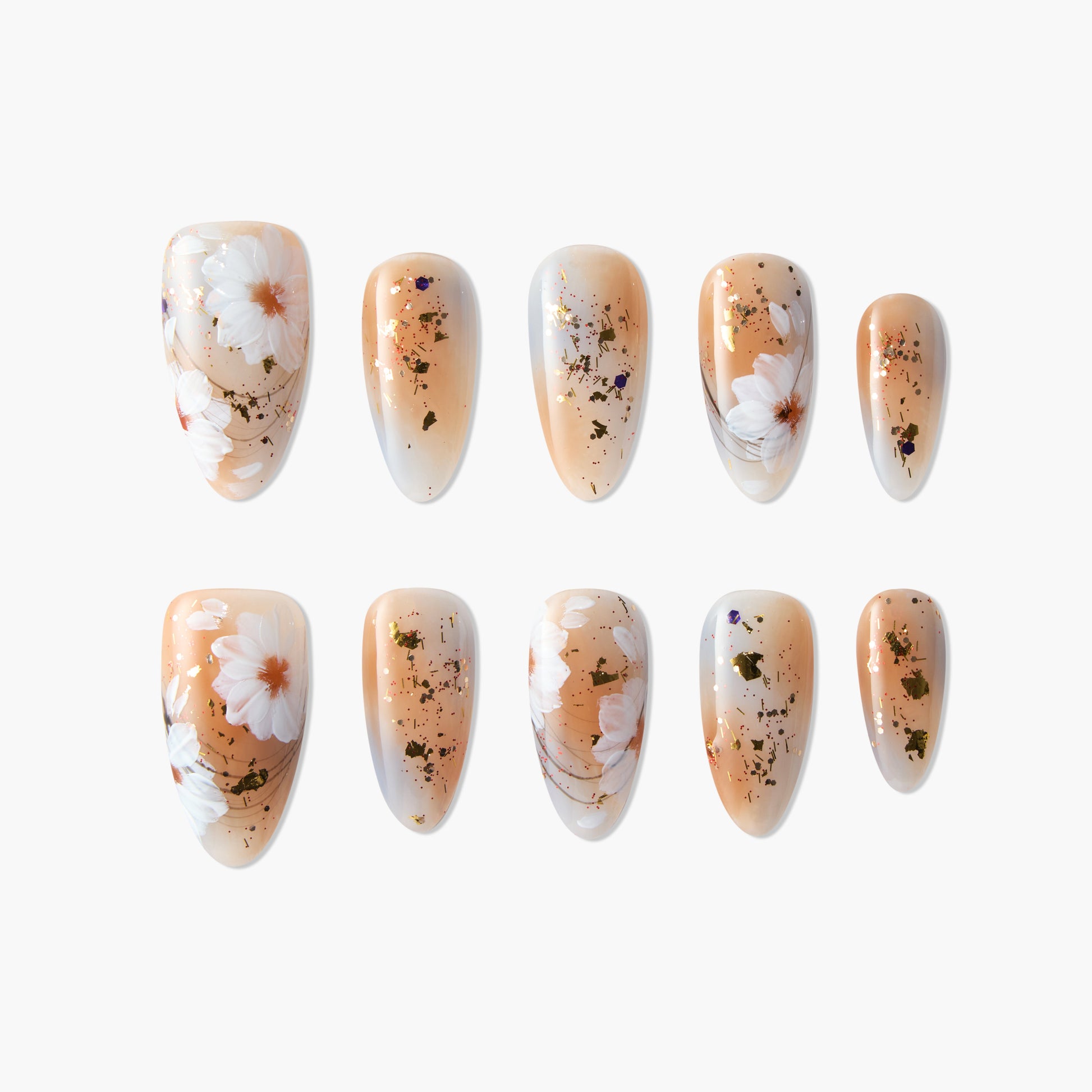 Handmade press-on nails with nude base, white daisy floral design, and gold foil accents.