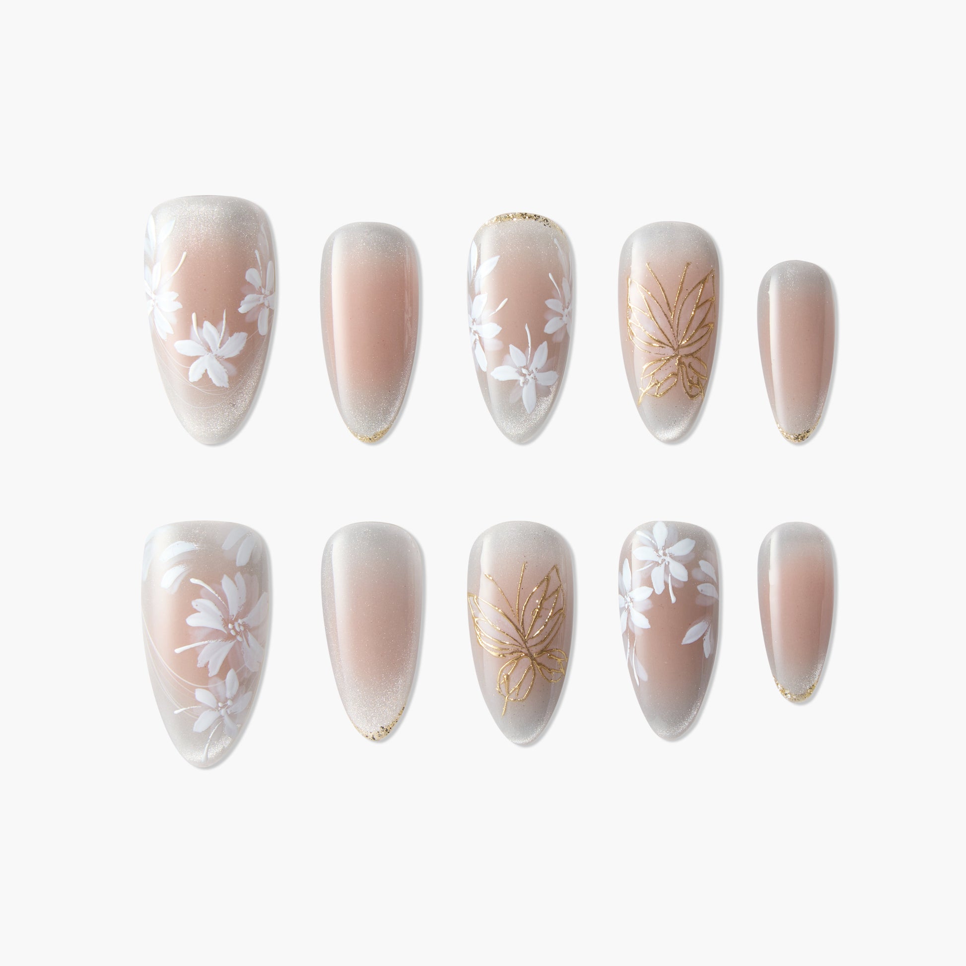 Handmade press-on nails with nude base, white floral designs and gold accents, arranged on white background.