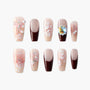 Handmade press-on nails with floral designs, pearls, glitter, and burgundy French tips