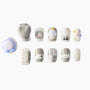 Handmade press-on nails with cute kitten, fish, and paw print designs in pastel and neutral tones.