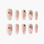 Handmade nude press-on nails with pink 3D bows and gemstone accents