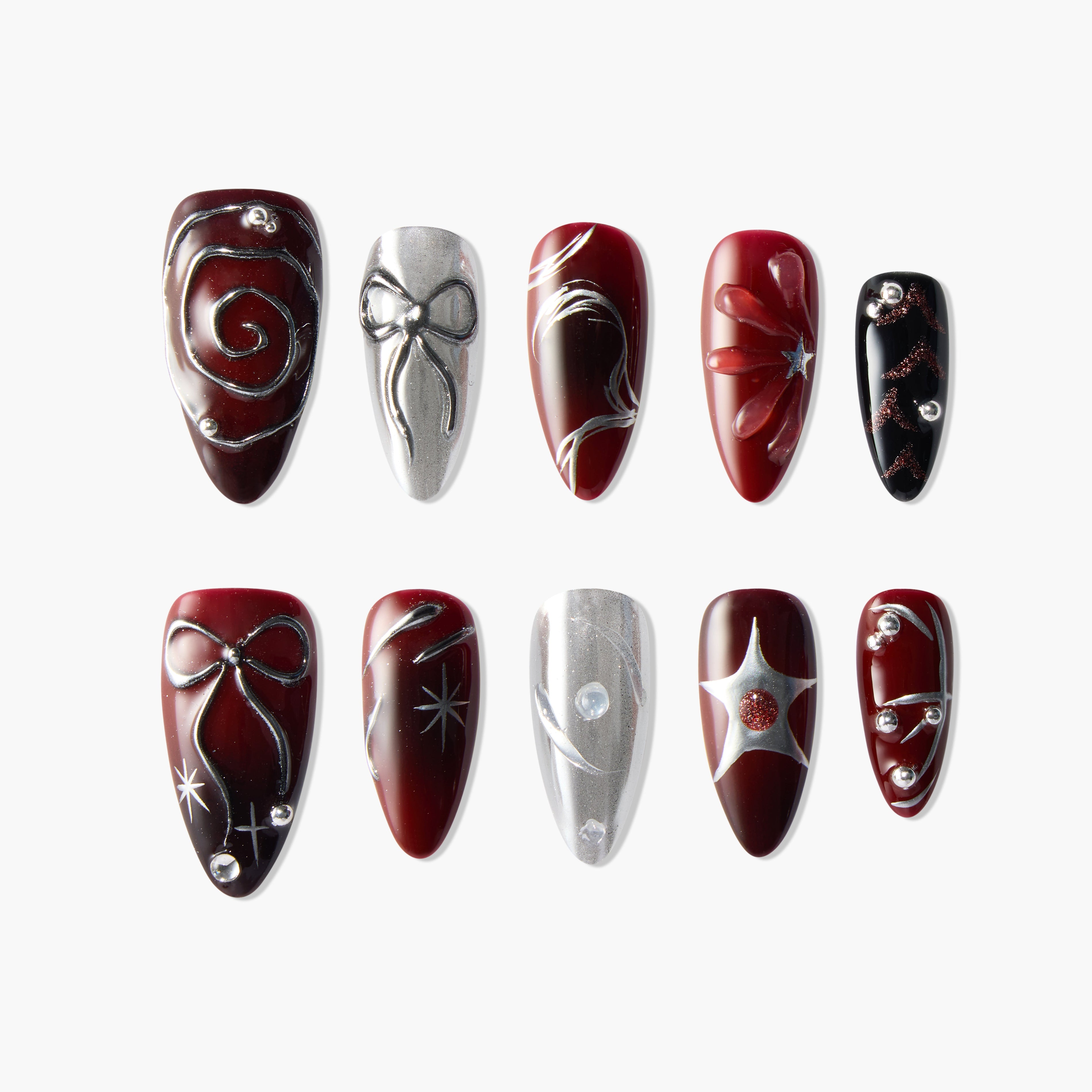 Handmade press-on nails in red, black, and silver with bow, swirl, star, and gem designs.