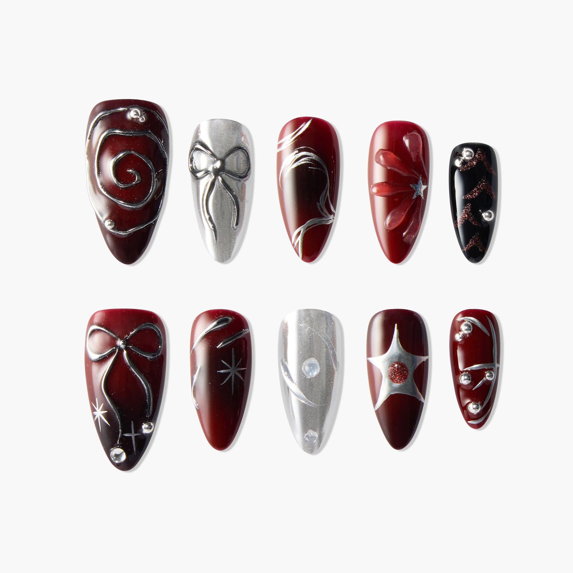 Handmade press-on nails in red, black, and silver with bow, swirl, star, and gem designs.