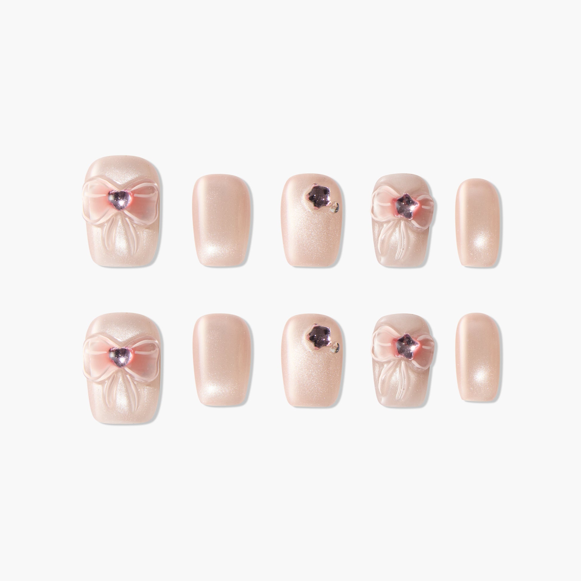 Handmade press-on nails in shimmery nude with pink 3D bows and rhinestone accents
