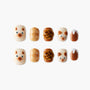 Cute press-on nails with cat faces, brown pastries, and dessert designs on white background