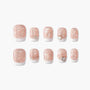 Set of pink glitter press-on nails with white tips and gemstone accents, displayed on white background.