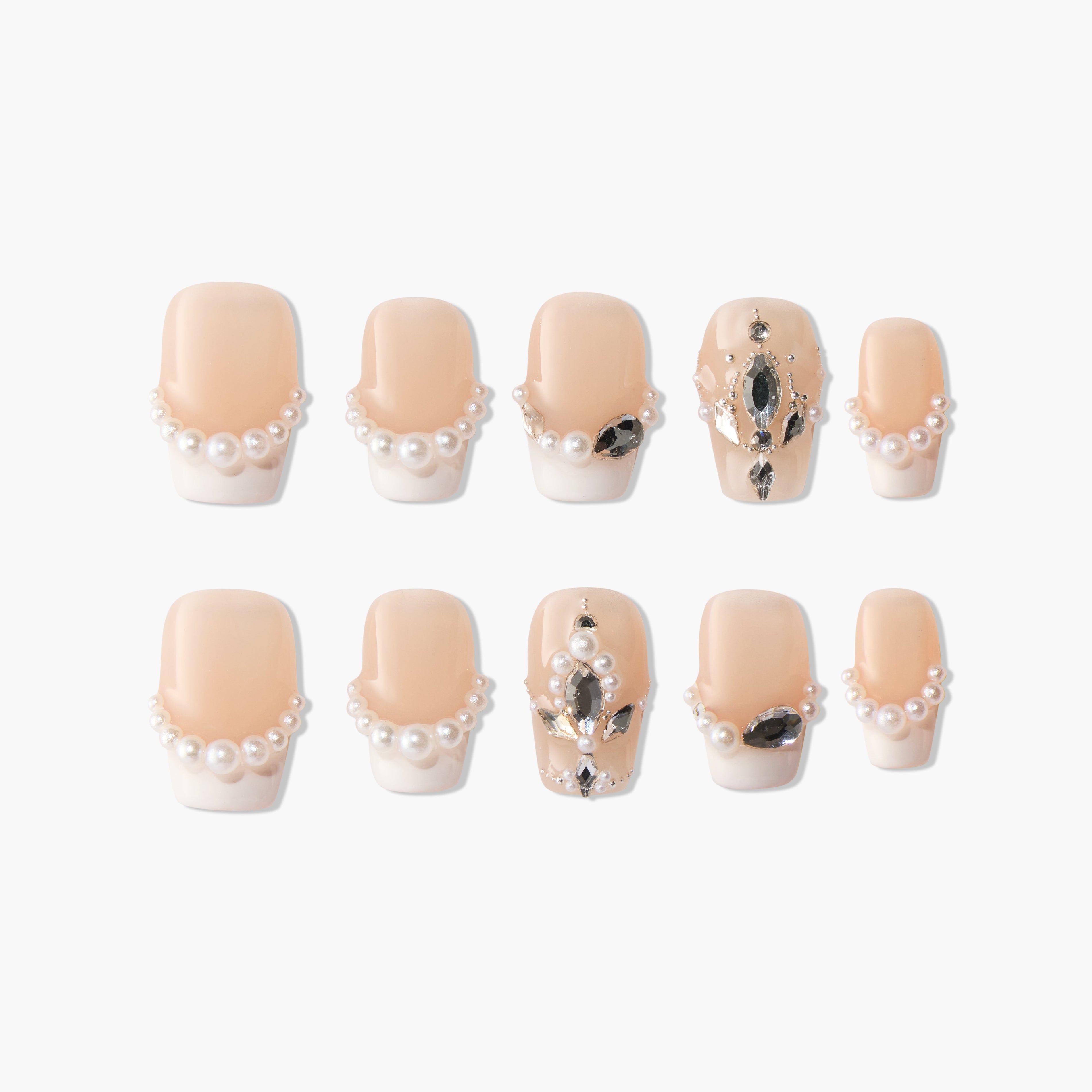 Handmade press-on nails with nude base, pearl accents, and black gemstone embellishments