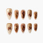 Handmade press-on nails with gold glitter, brown butterfly accents, and beige ombre design.