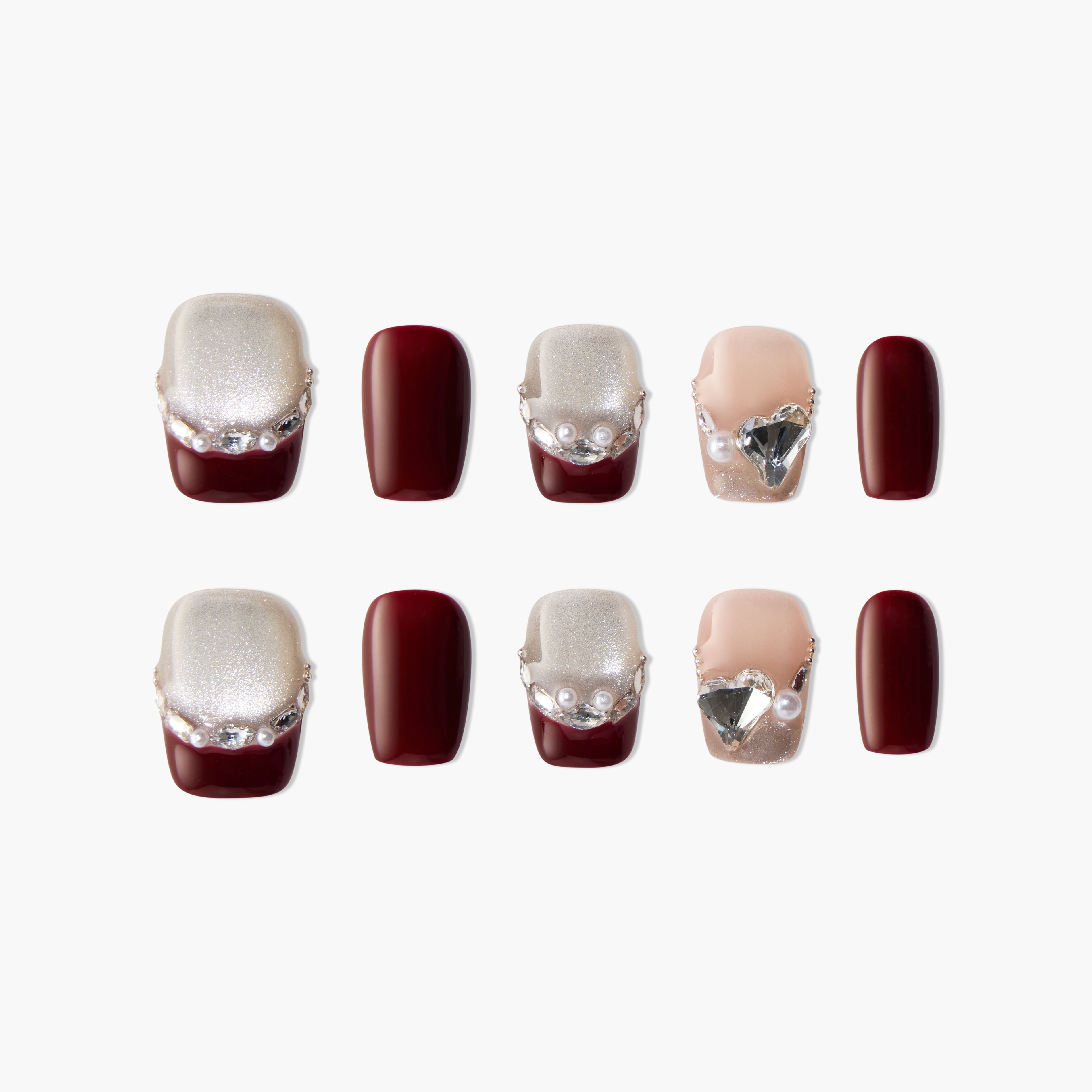 Handmade press-on nails in burgundy, glitter, and nude with pearl and gem accents, stylish set