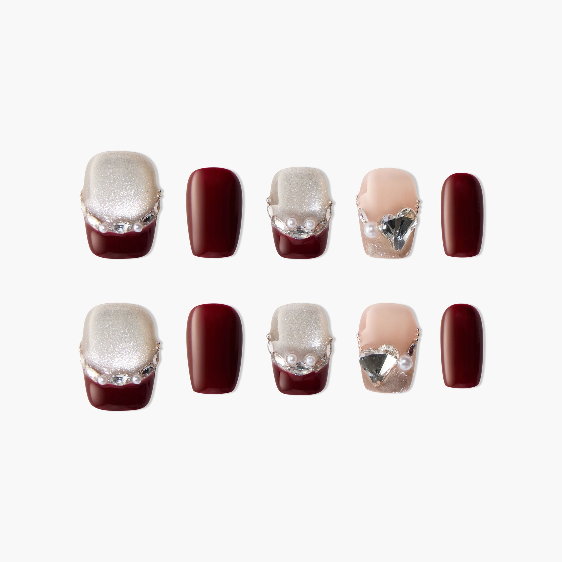 Handmade press-on nails in burgundy, glitter, and nude with pearl and gem accents, stylish set
