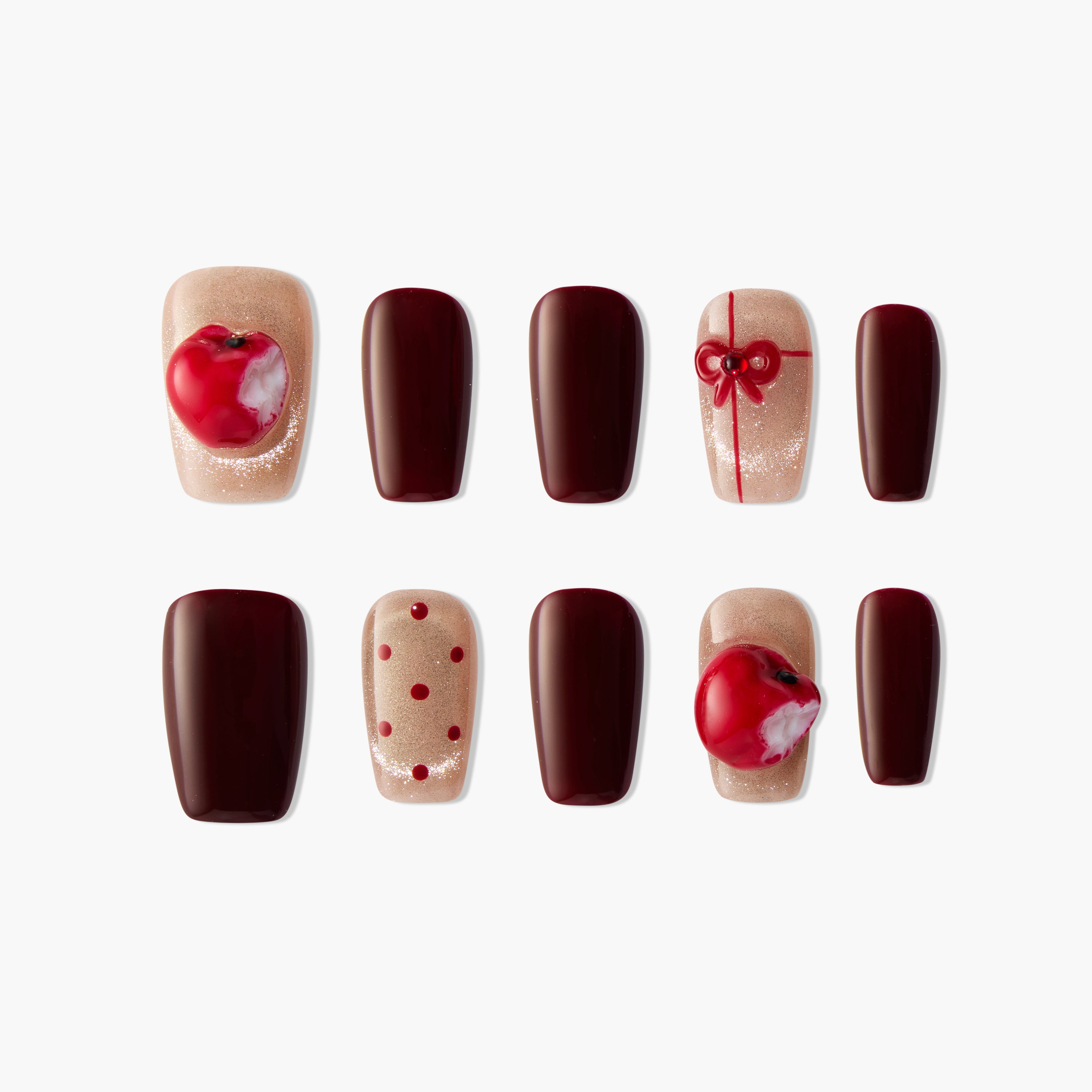 Handmade press-on nails with burgundy, nude glitter, apple and bow designs, polka dots.