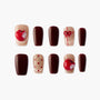 Handmade press-on nails with burgundy, nude glitter, apple and bow designs, polka dots.