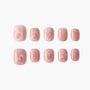 Pink glitter press-on nails with subtle heart designs arranged on a white background.