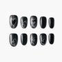 Black press-on nails with silver glitter and heart design, arranged on a white background.