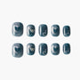 Glittery blue handmade press-on nails with silver heart, bow, and dot accents, set of ten