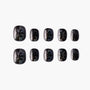 Black press-on nails with holographic glitter and abstract patterns, set of ten on white background