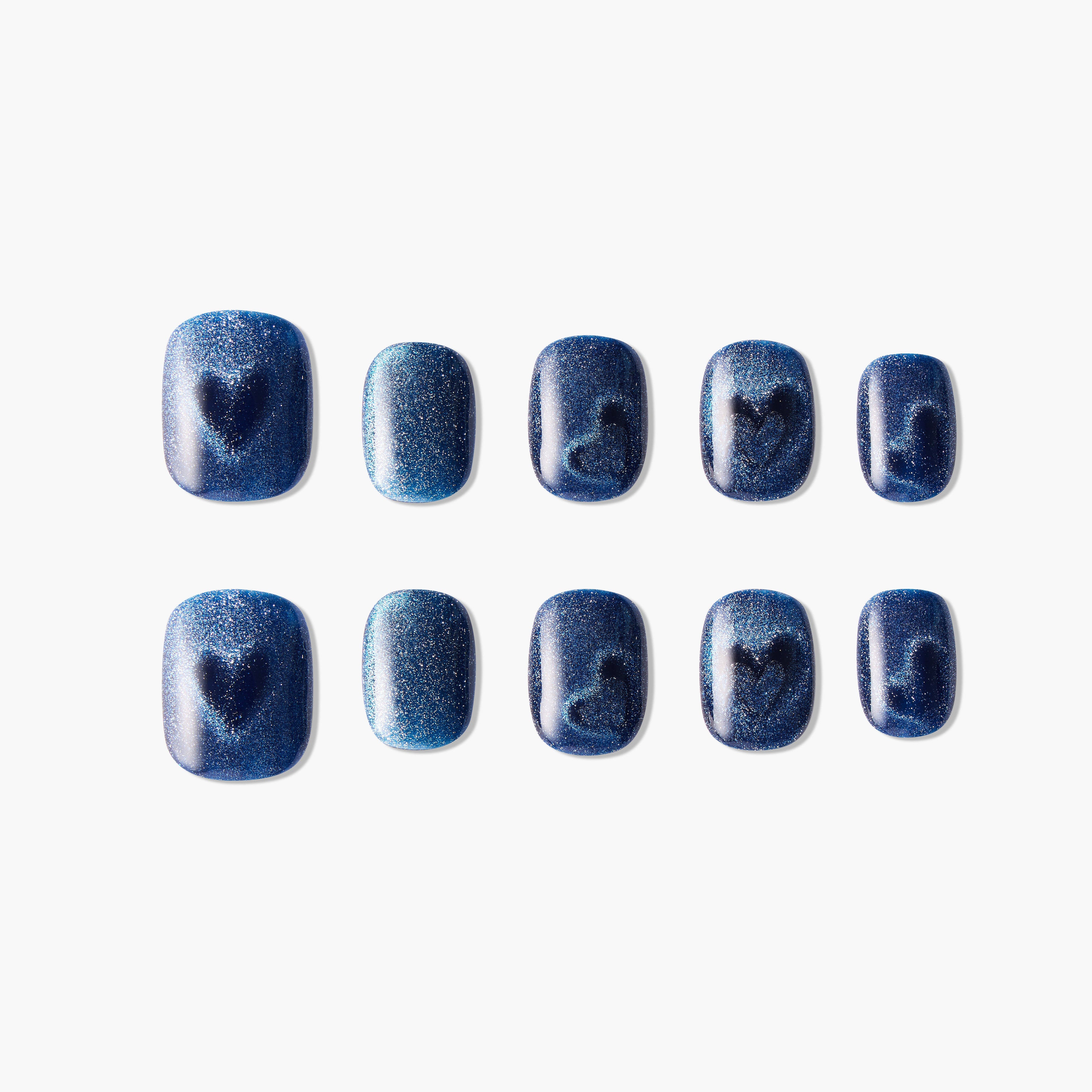 Set of blue glitter press-on nails with heart and swirl designs, displayed on white background.