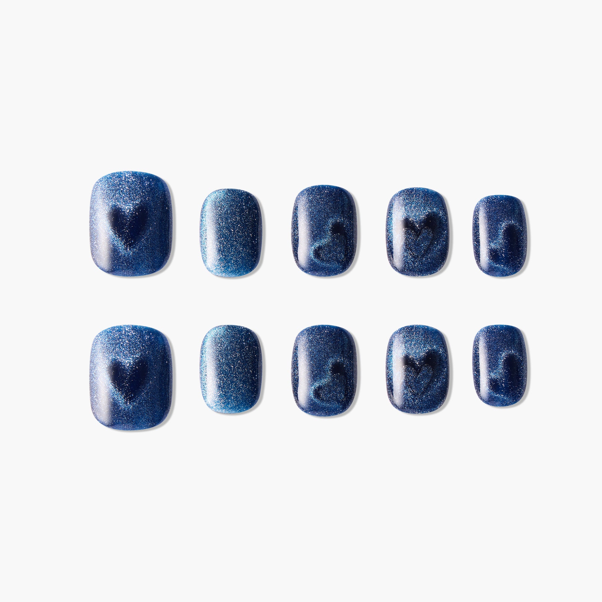 Set of blue glitter press-on nails with heart and swirl designs, displayed on white background.