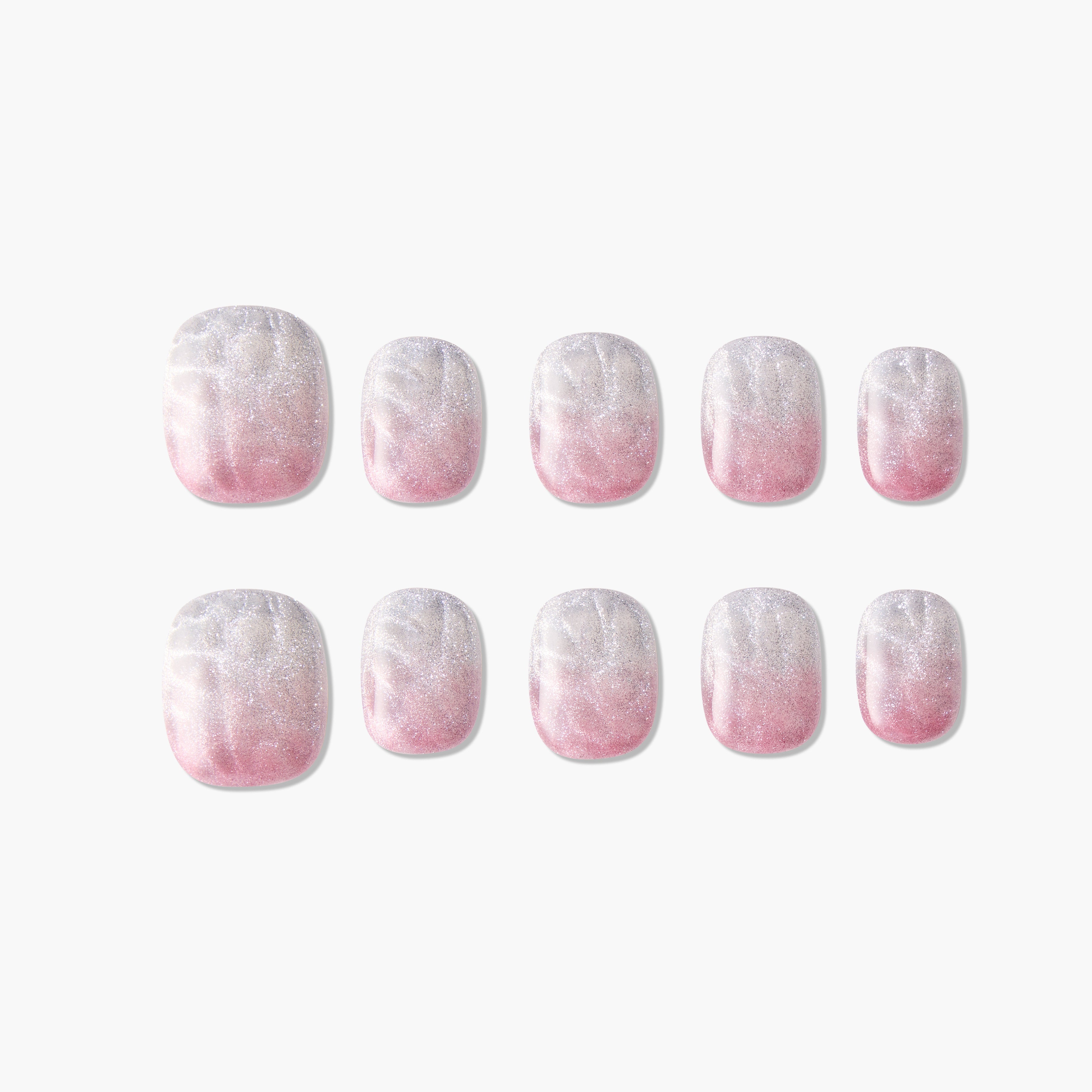 Set of pink and white ombre press-on nails with glitter and marble effect on white background