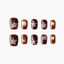 Brown press-on nails with glittering star rhinestone accents and metallic gold details