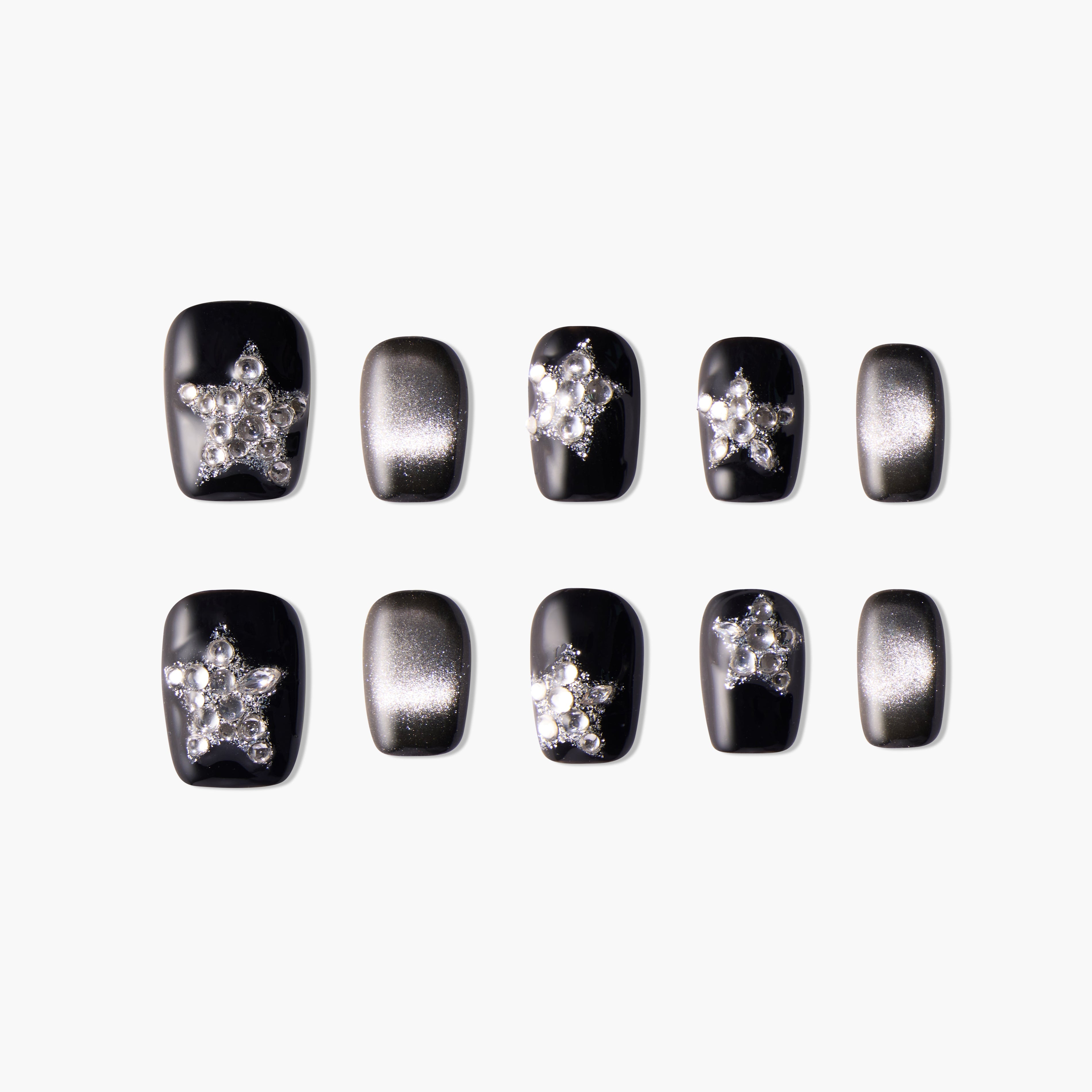 Black and silver press-on nails with star-shaped rhinestone accents, glossy finish