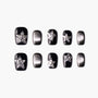 Black and silver press-on nails with star-shaped rhinestone accents, glossy finish