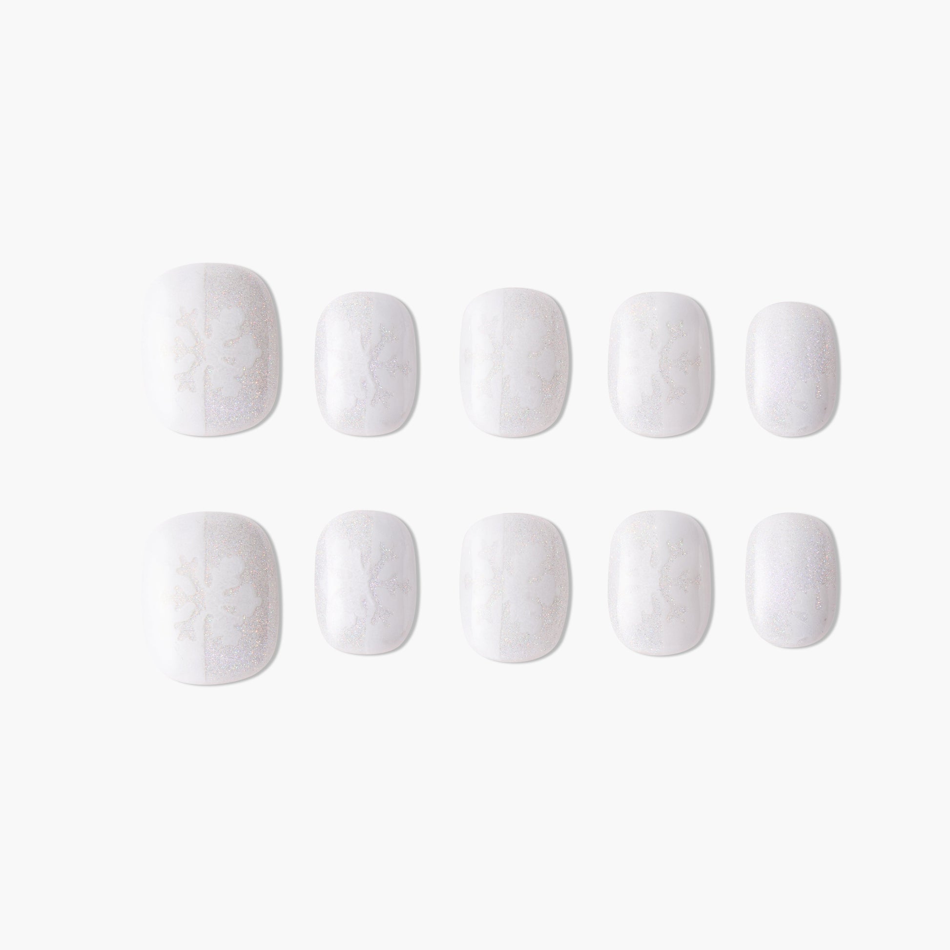 Handmade white press-on nails with subtle snowflake and glitter design on plain background