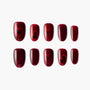Handmade red press-on nails with glossy finish and subtle heart designs, reusable manicure