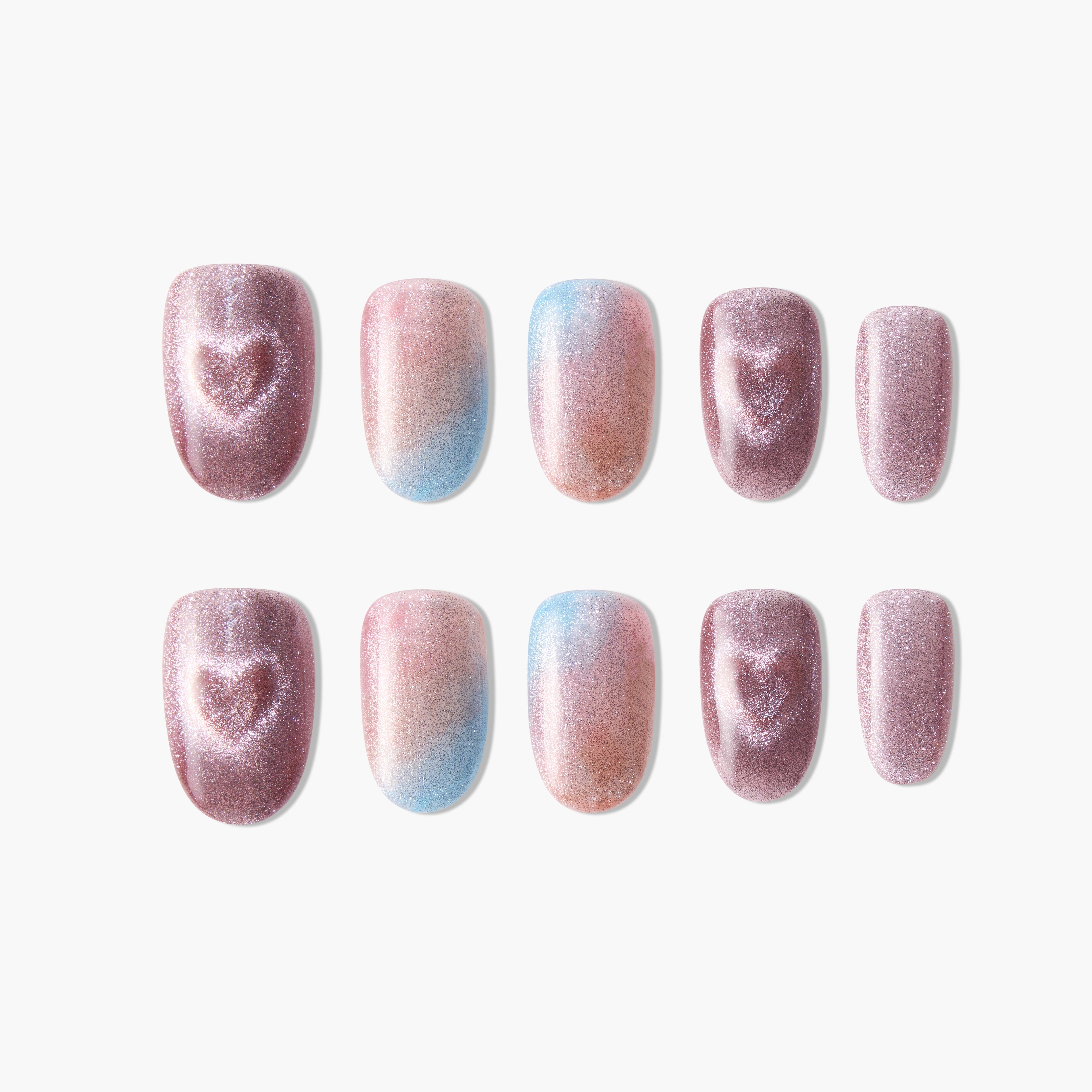 Glitter press-on nails in pink, blue, and nude gradient with heart designs, arranged on white