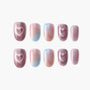 Glitter press-on nails in pink, blue, and nude gradient with heart designs, arranged on white