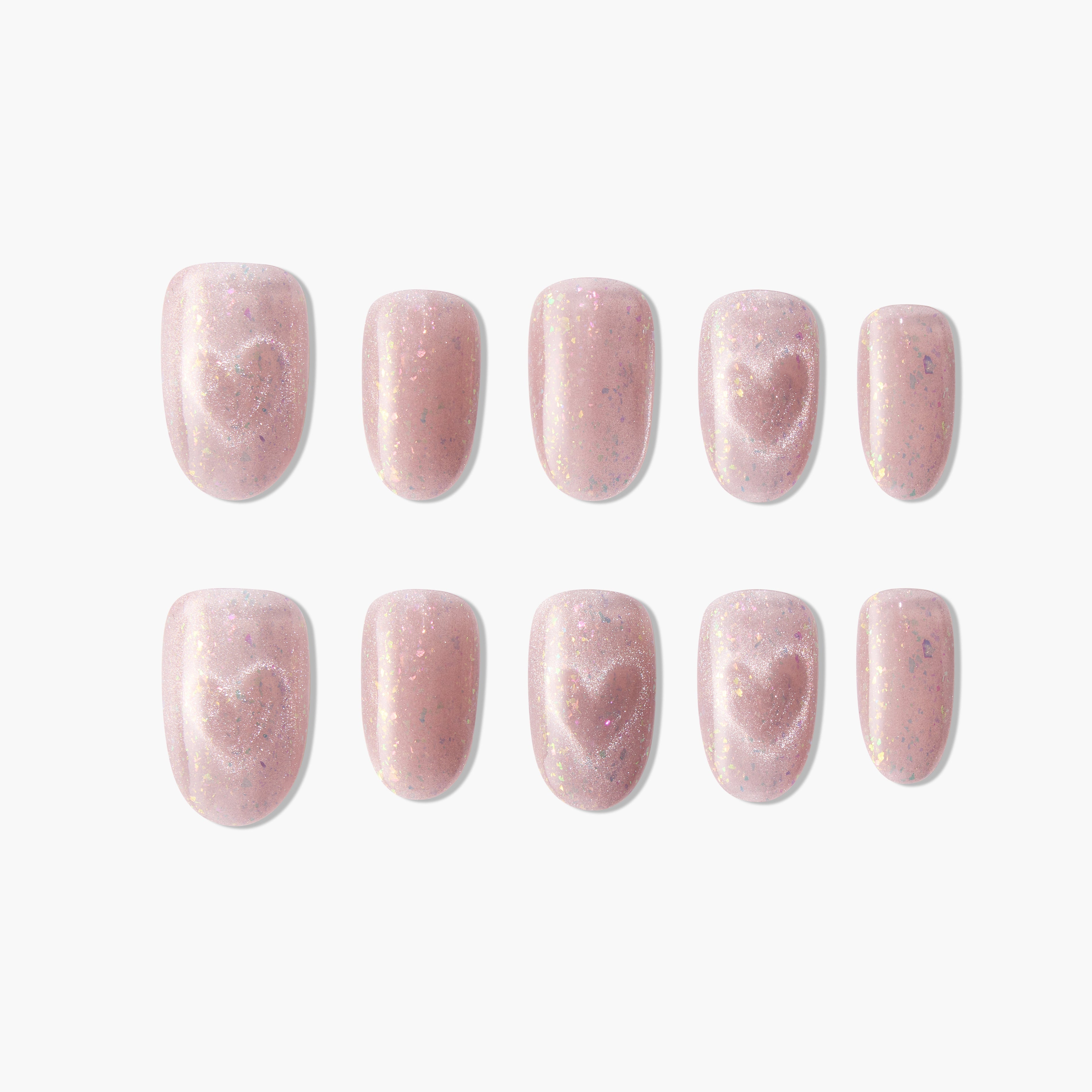 Pink glitter press-on nails with heart design, arranged on a white background