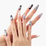 Hand with long stiletto press-on nails in black, silver, and gray marble designs with 3D accents