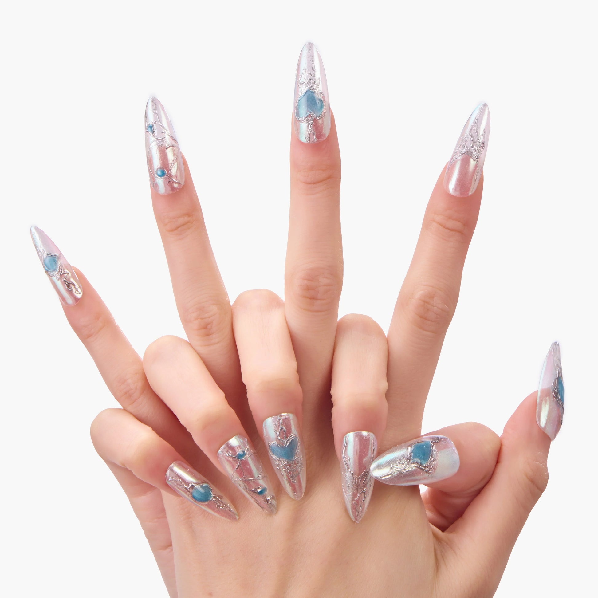 Hand displaying long stiletto silver press-on nails with blue heart and gem accents.