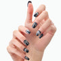 Hand with glossy black press-on nails featuring silver glitter and rhinestone accents.
