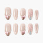 Handmade press-on nails with nude polish, pearl accents, pink bows, and gold tips