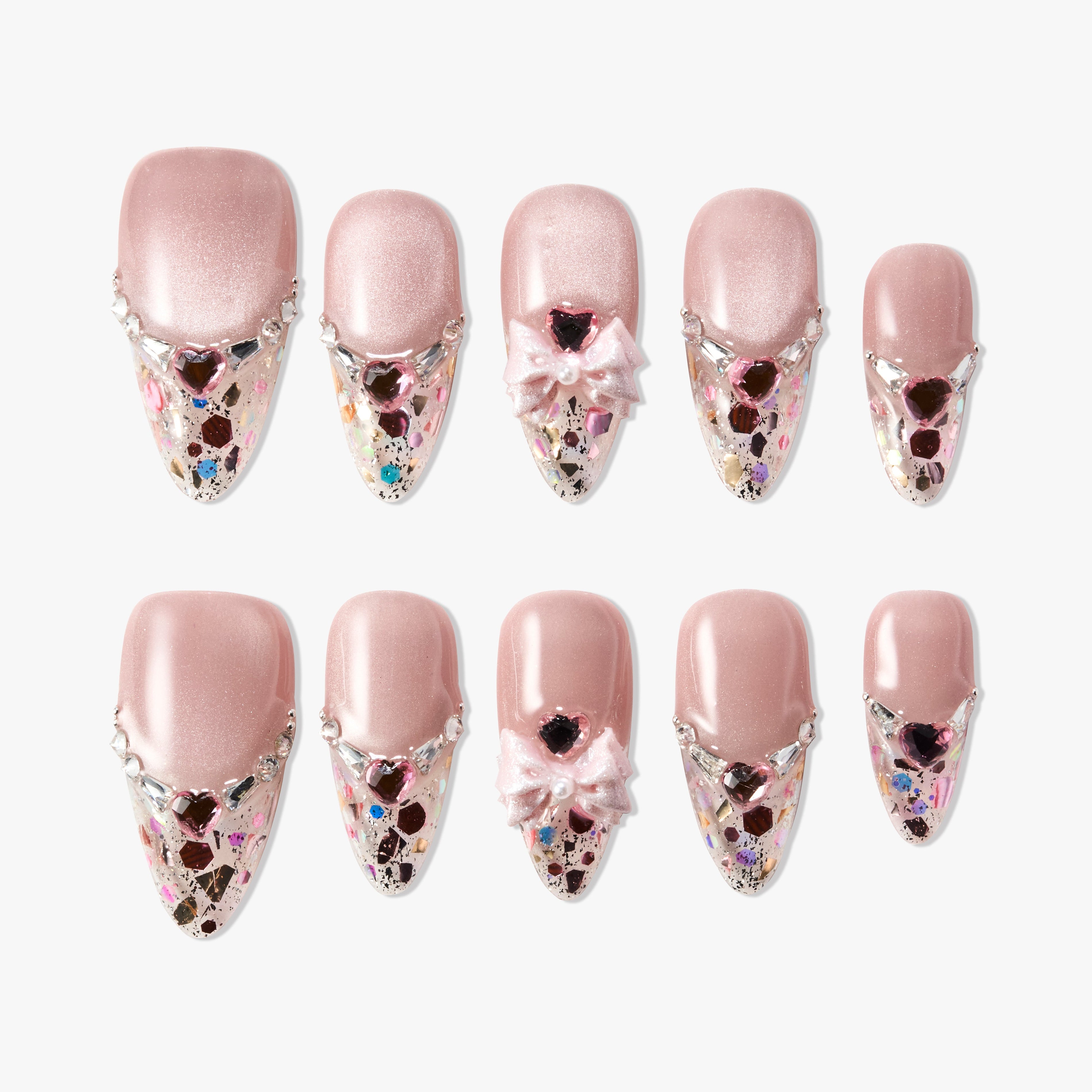 Pink press-on nails with glitter, rhinestones, heart gems, and 3D bows on a white background.