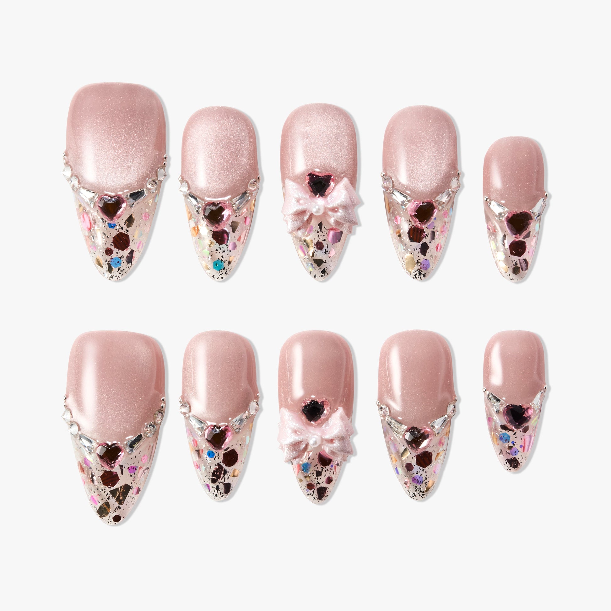 Pink press-on nails with glitter, rhinestones, heart gems, and 3D bows on a white background.