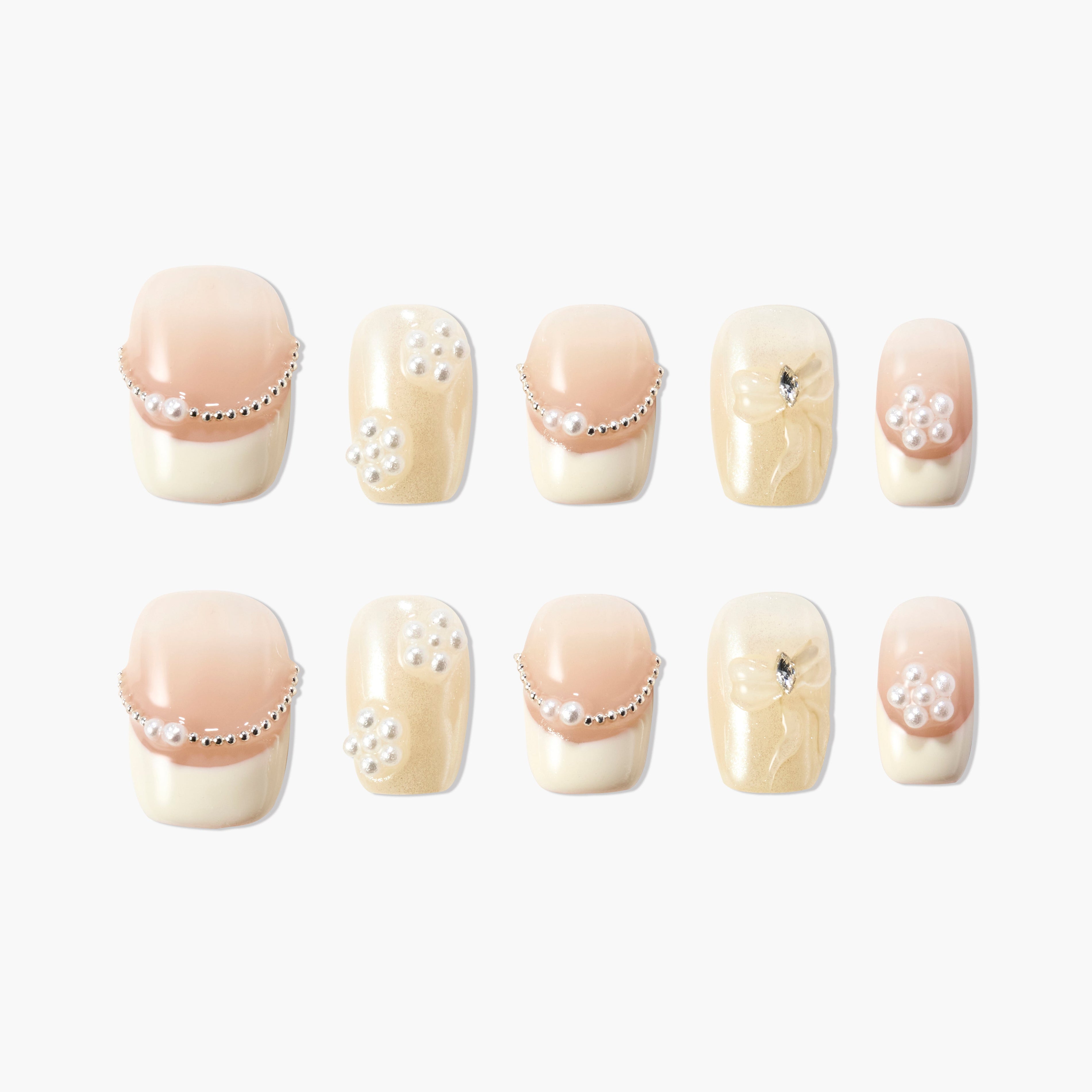 Handmade press-on nails with nude and pearl accents, gold shimmer, and rhinestone details