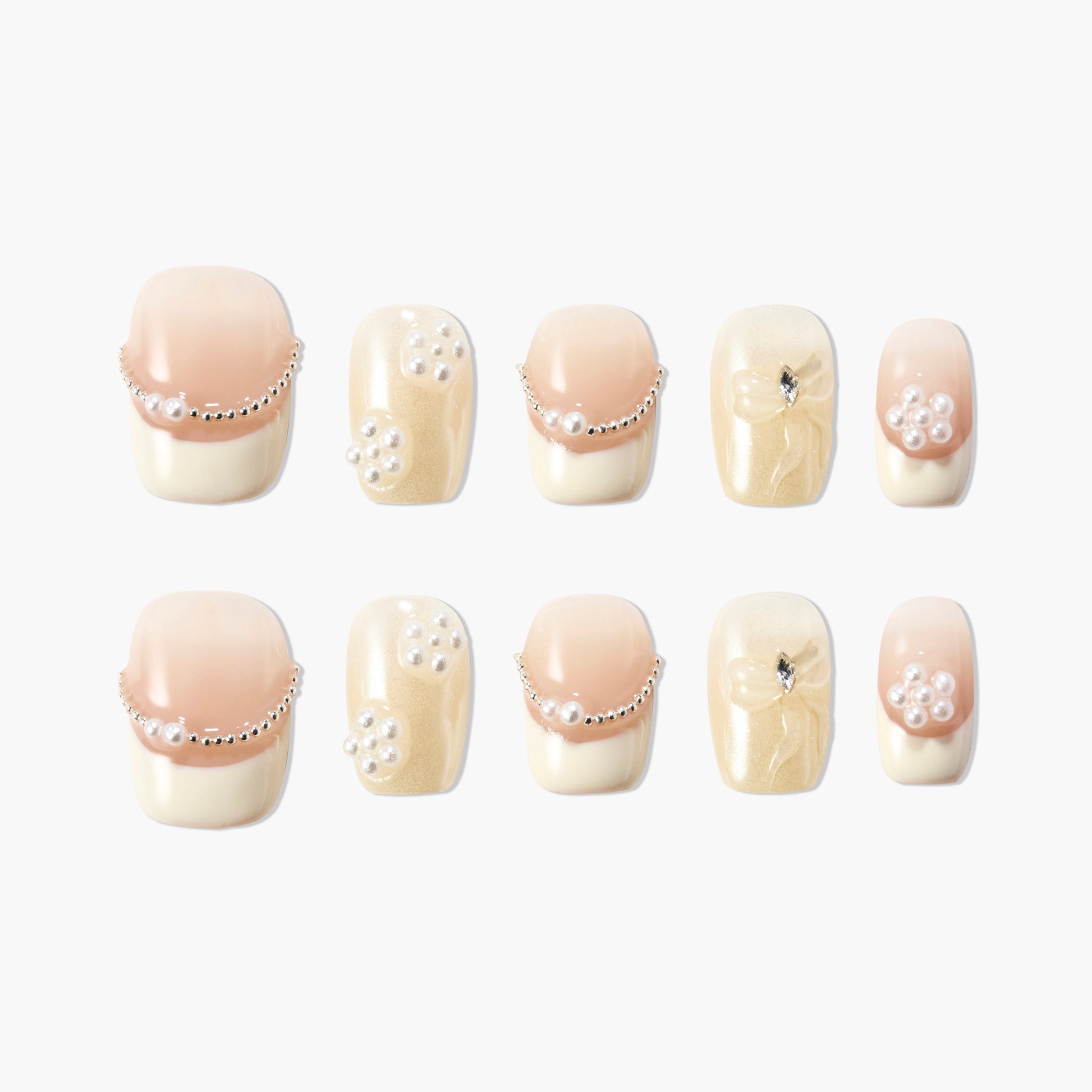 Handmade press-on nails with nude and pearl accents, gold shimmer, and rhinestone details