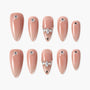 Almond-shaped nude press-on nails with rhinestone and gem accents, elegant nail art set