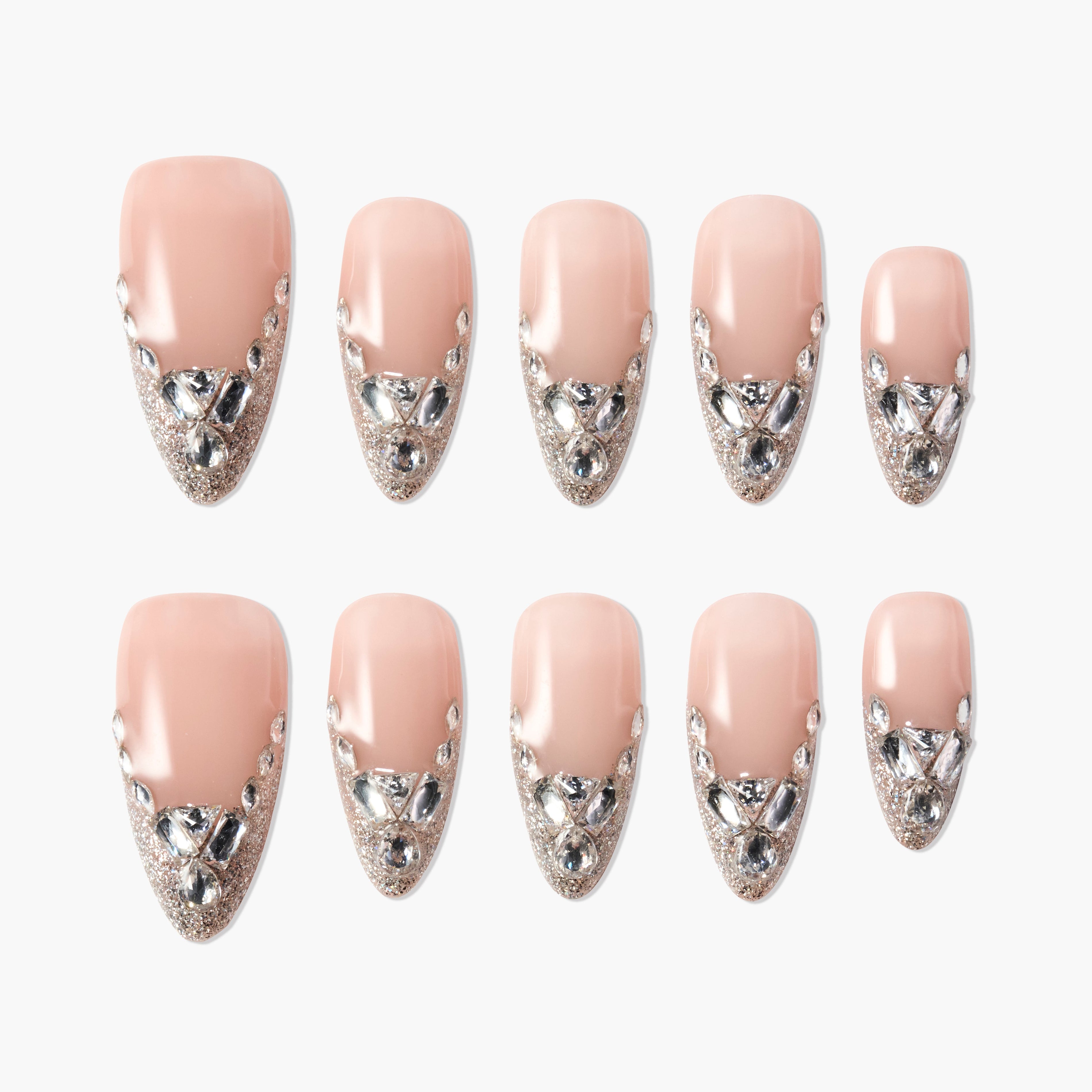Nude press-on nails with silver glitter tips and rhinestone accents, arranged on white background