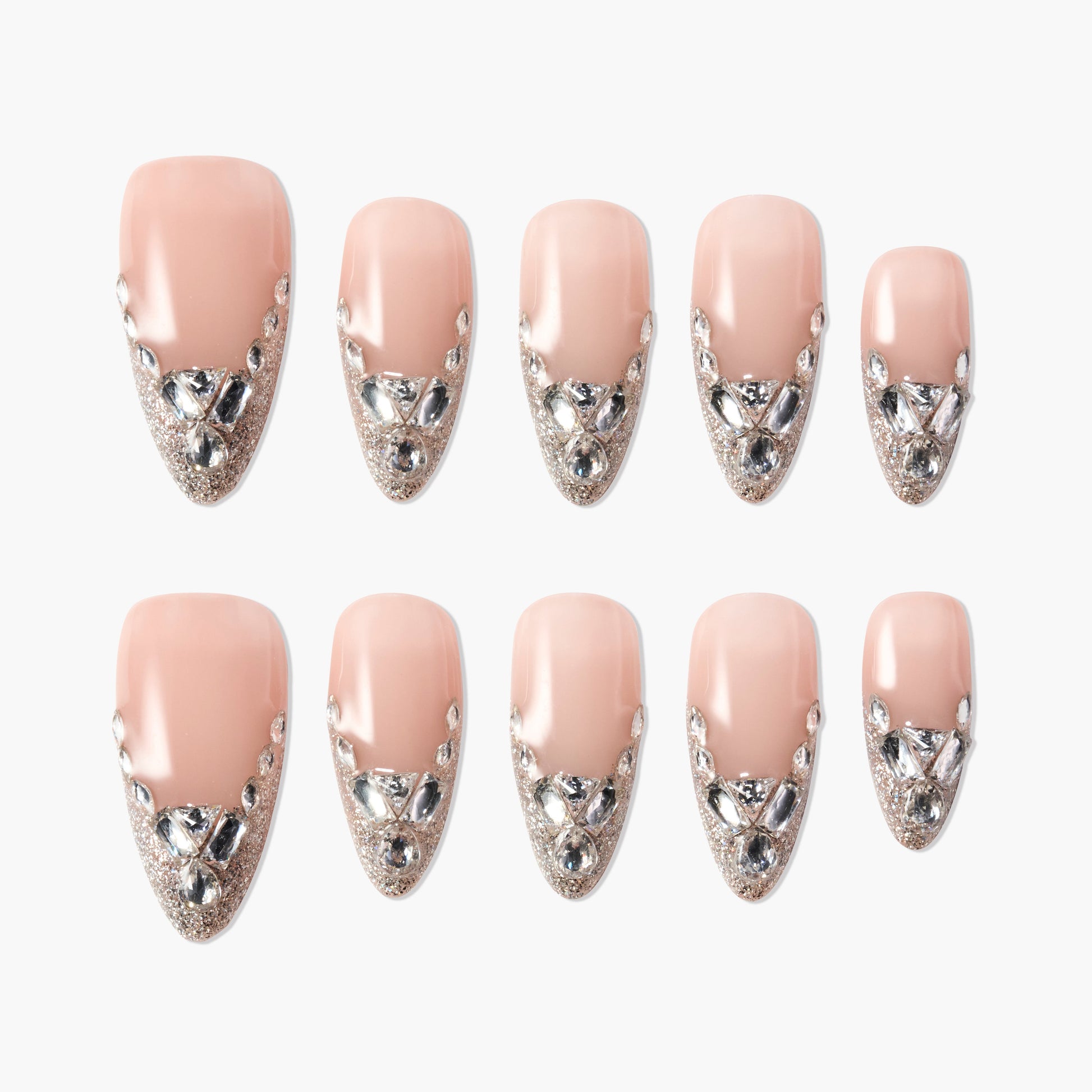 Nude press-on nails with silver glitter tips and rhinestone accents, arranged on white background