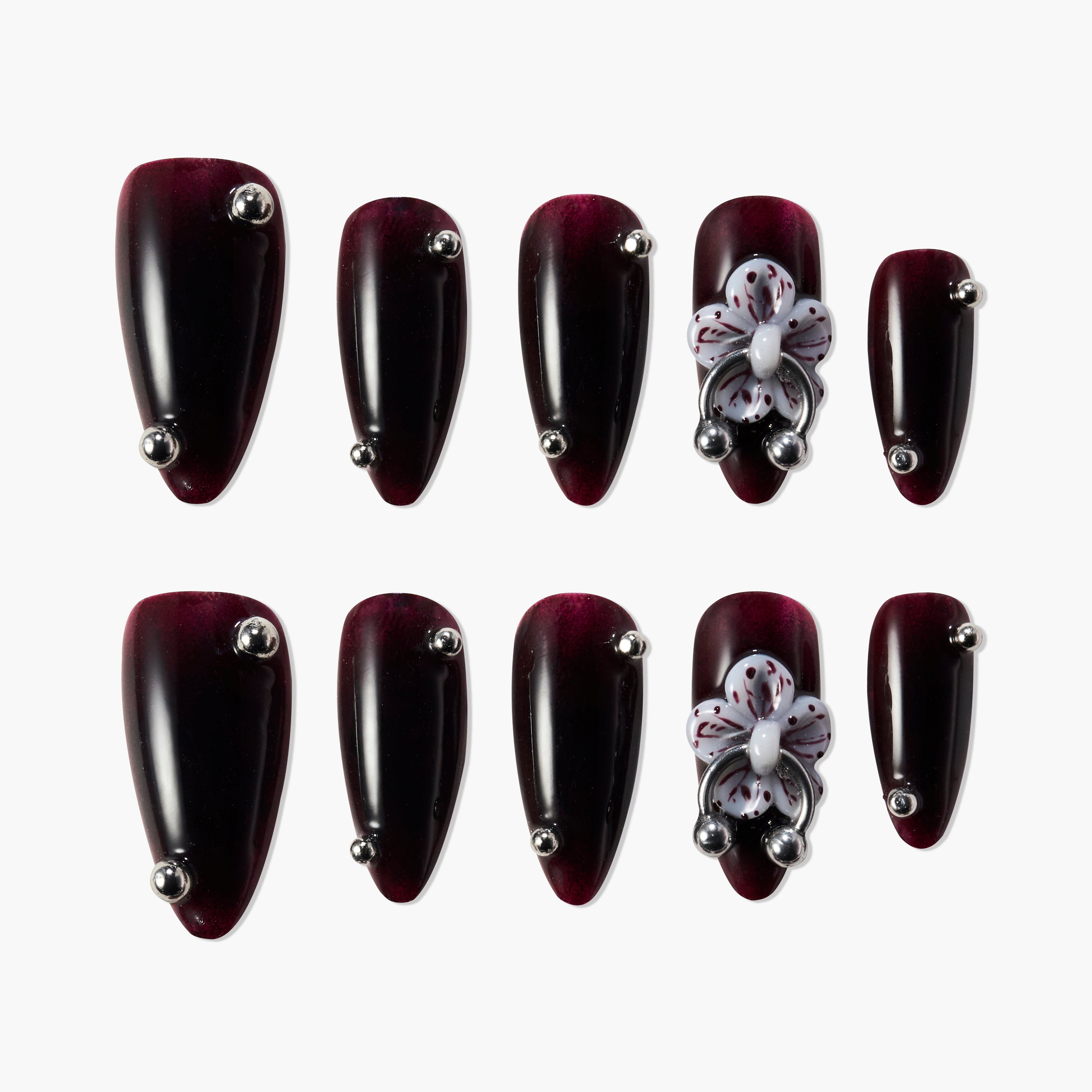 Dark burgundy press-on nails with silver studs and 3D white floral accents, glossy finish
