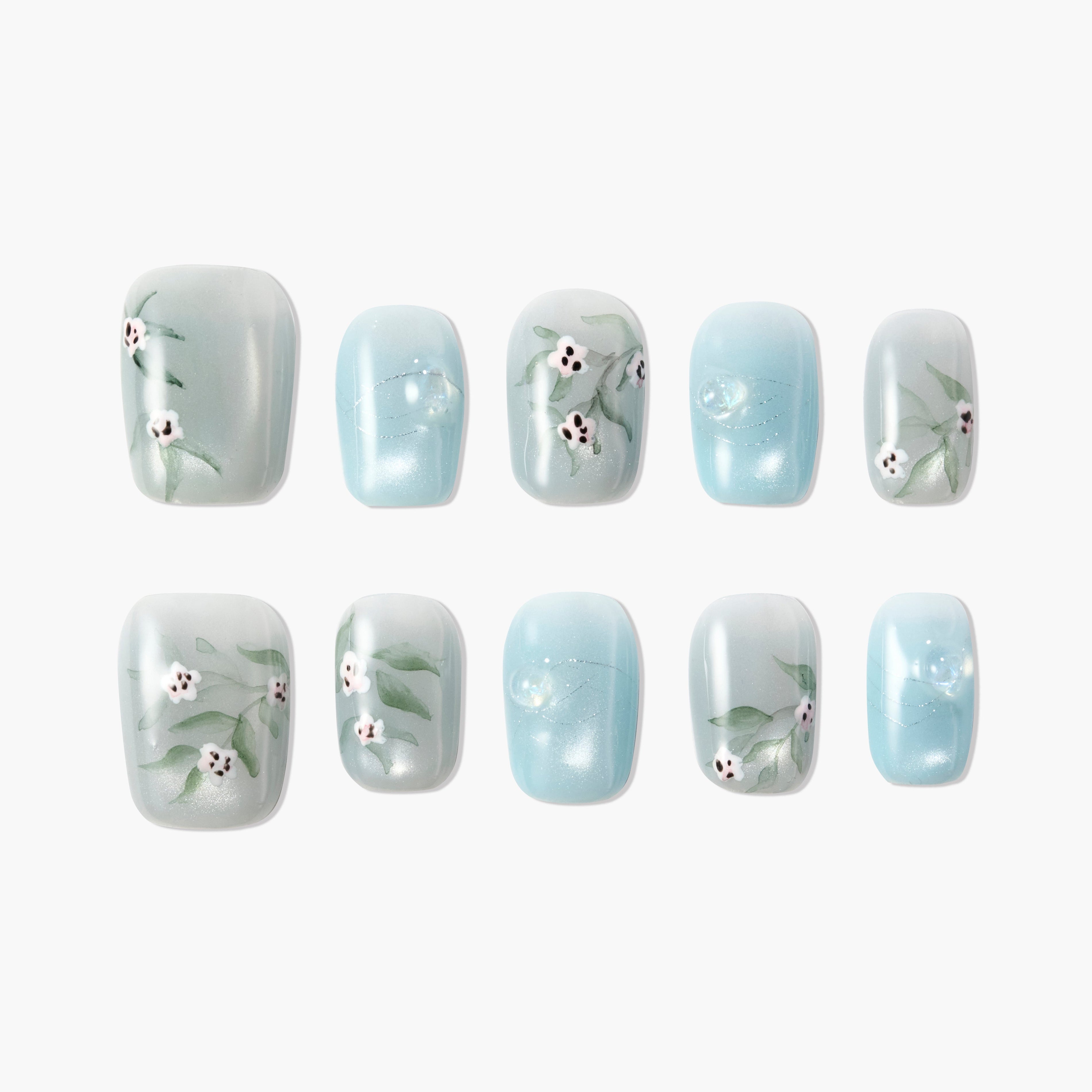 Blue and white handmade press-on nails with floral design and pearl accents, arranged on white background